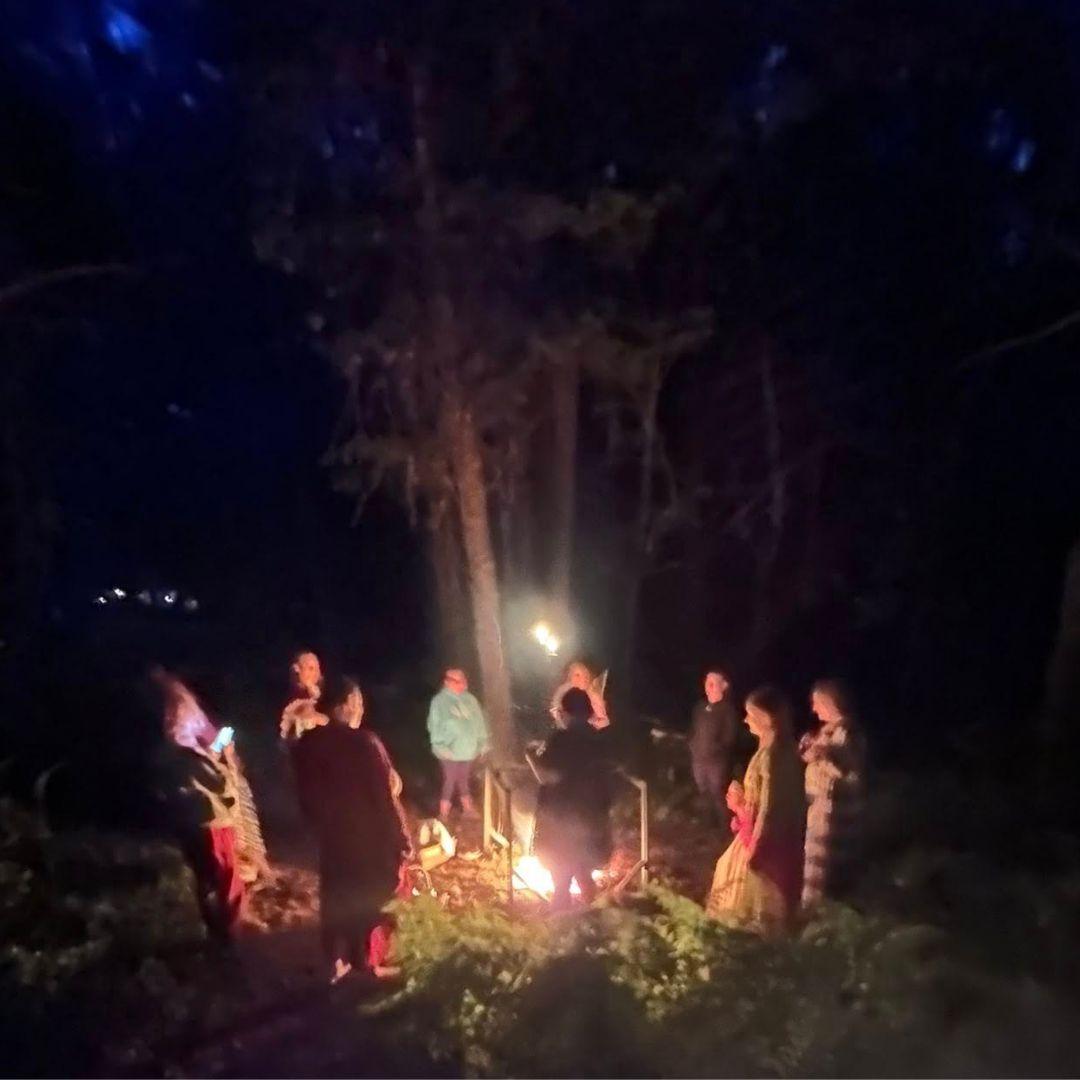 people around a fire and cauldron in forest<br />
