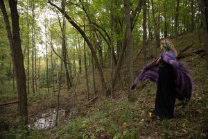 women in forest twirling with shawl