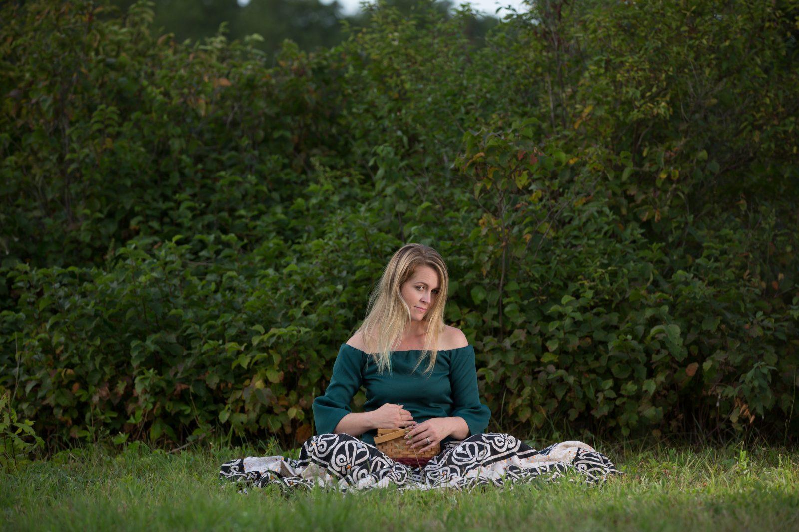 lady holding a basket sitting on the ground