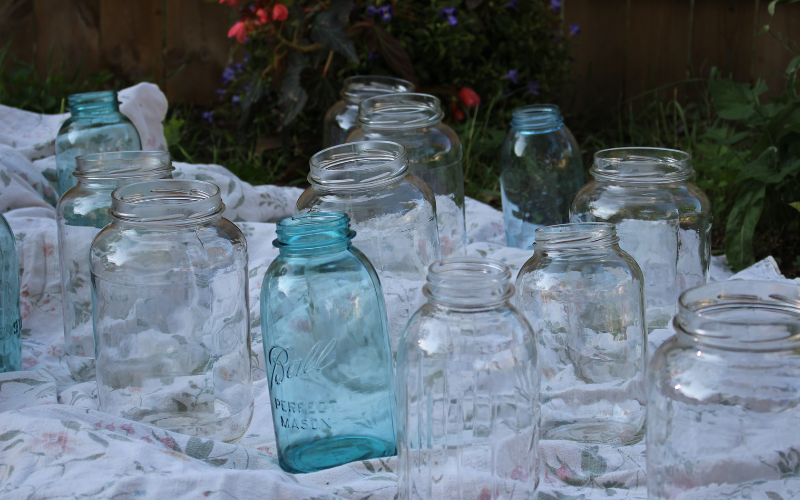 a blanket on the ground with empty jars